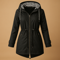 Woman wearing a waterproof parka with adjustable waist, two-way zipper, and windproof exterior, ideal for wet and windy weather.